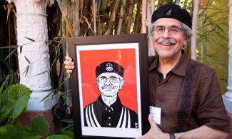 CRLA Executive Director Jose Padilla holds portrait created by Lalo Alcaraz September 2022